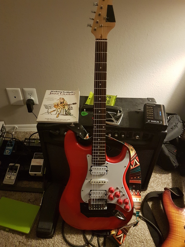 The guitar, with duct-tape on the bridge and headstock.